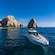 2 people relaxing on a yacht at the Arch of Cabo San Lucas rock formation